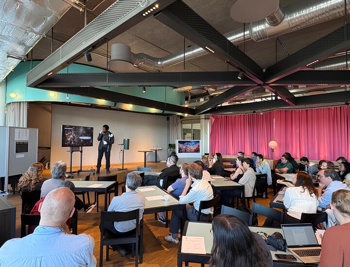 A speaker presents science-inspired work to an audience at ScientiFikART 2026.