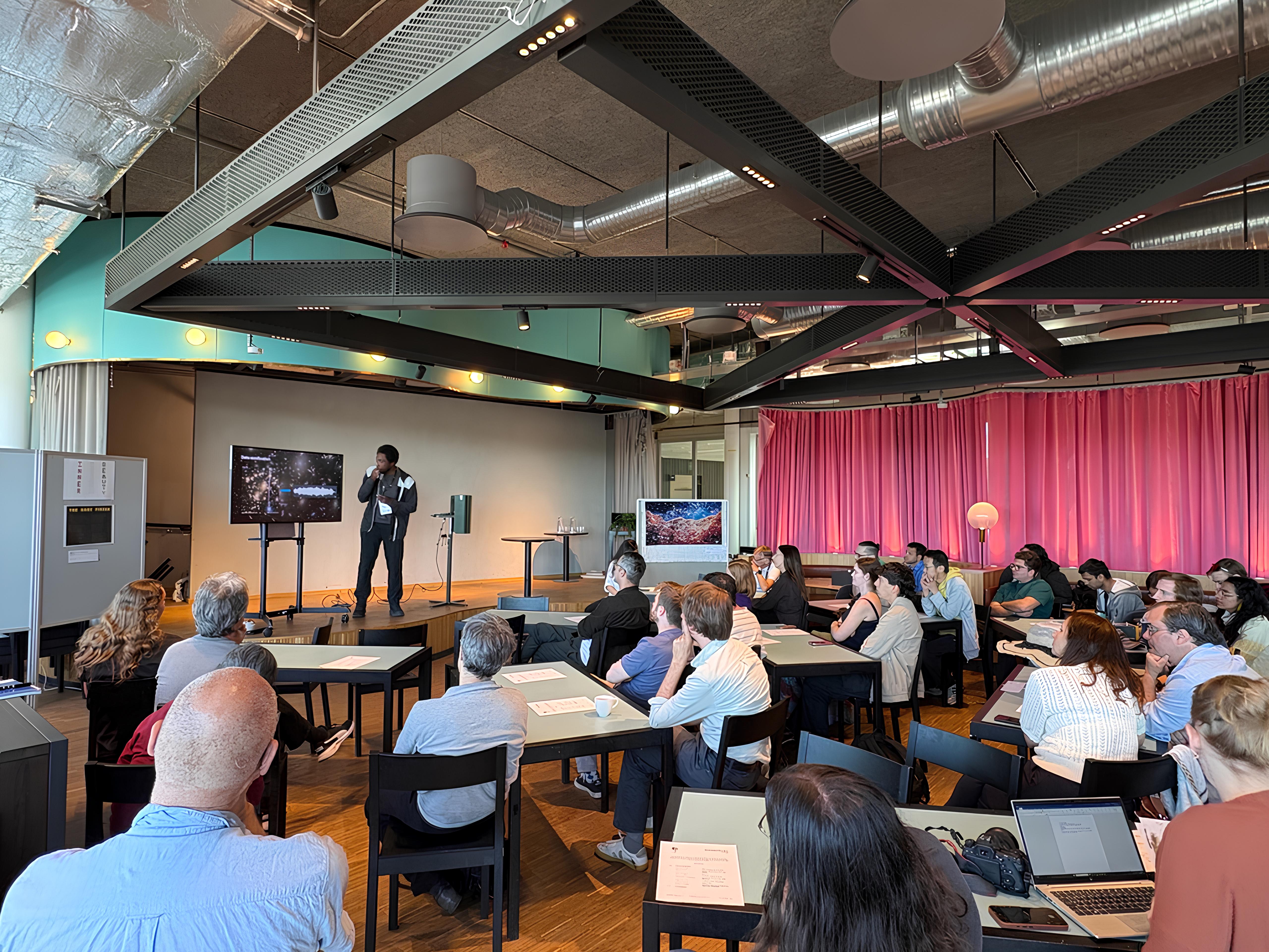 A speaker presents science-inspired work to an audience at ScientiFikART 2026.
